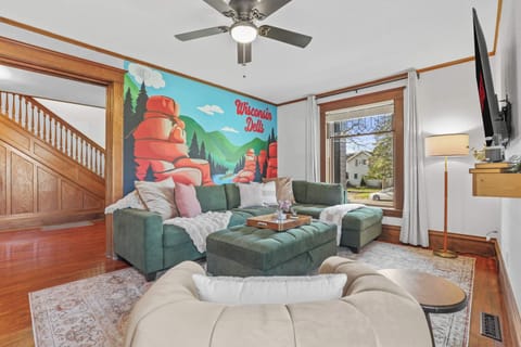 Our cozy main level living room features a large sectional, accent chair, black out curtains, 65" smart TV, and an open concept into the dining room room and kitchen area.