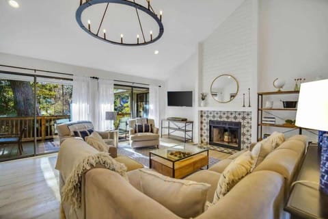 Relax in your bright, airy living room with soaring ceilings, cozy fireplace, and stunning chandelier creating the perfect atmosphere for unwinding.