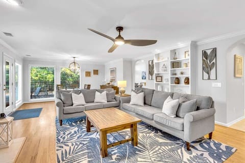 Spacious living room with modern gray sofas and natural light from large windows.