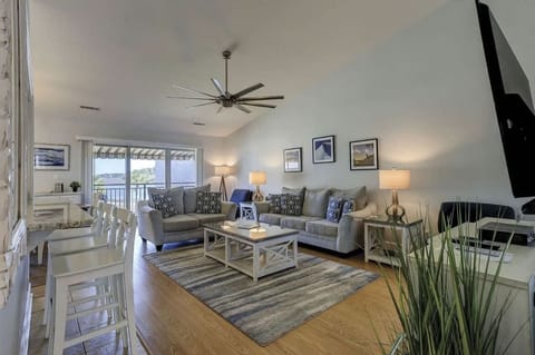 Spacious living room with comfortable seating and a view of the water through sliding glass doors.
