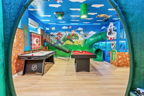 Step into a vibrant playroom adorned with whimsical murals and a fun slide, perfect for imaginative play. With a sleek air hockey table and a pool table, this lively space invites friendly competition and endless entertainment.