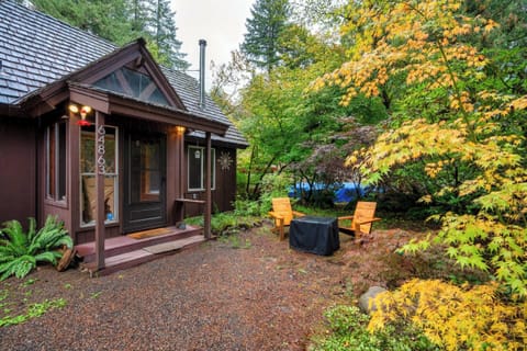 Storybook cabin tucked into the maples, with fireside chairs out front