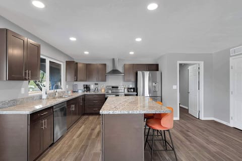 Dine in style at this elegant, minimalist table set beneath warm lighting. The open layout connects seamlessly to the living space, creating a relaxed and social atmosphere.