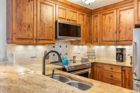 Fully equipped kitchen with modern appliances and warm wood cabinetry—great for cooking at home.