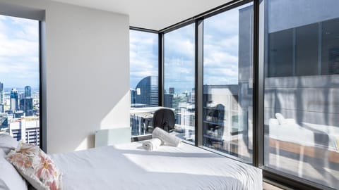 Inviting guest bedroom with soft bedding and city backdrop