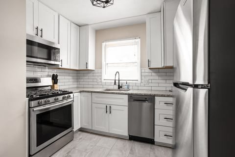 Modern kitchen with stainless steel appliances, subway tile backsplash and all of the necessities for your stay!
