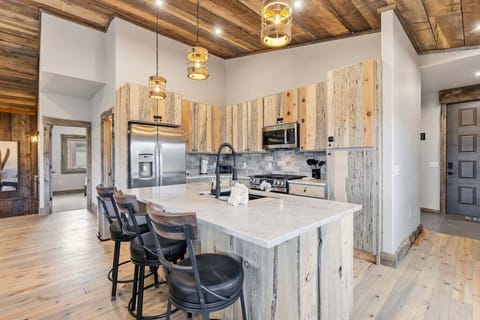 Gather around this gorgeous kitchen island where rustic wood beams and modern appliances create the perfect cooking sanctuary for your mountain retreat.