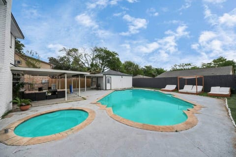 Hot tub and patio view with string lights and covered seating.