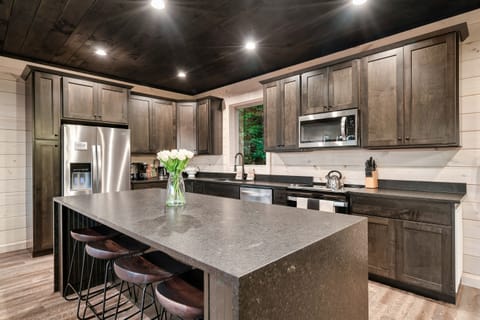 The fully equipped gourmet kitchen is open to the living area, with central island, perfect for preparing a meal, or hosting a family gathering. Kitchen is fully stocked with everything you and your family will need.