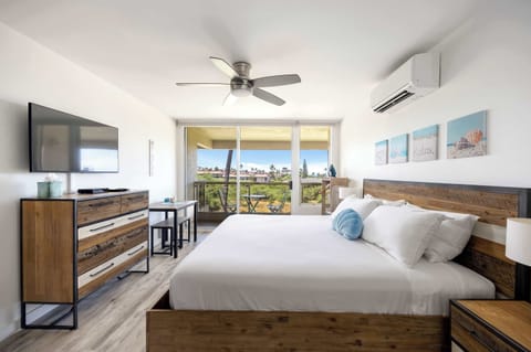 Enjoy a comfortable stay in your bright studio featuring a king bed with a wooden bed frame, split air conditioning, a 32" flat-screen TV, and sliding glass doors to the balcony.
