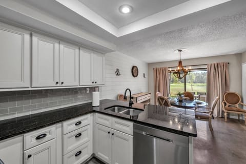 Prepare your favorite dishes while staying part of the conversation — the kitchen opens to the dining room with beautiful views beyond.