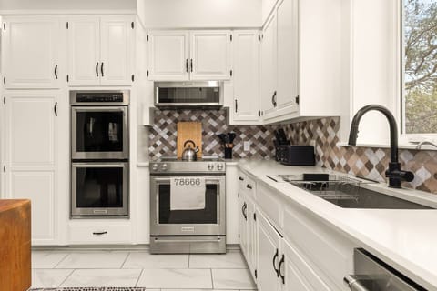 Cook with ease in this beautifully organized kitchen featuring three ovens, sleek finishes, and thoughtful details.