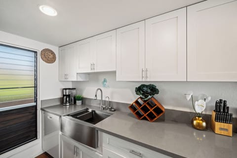 Compact kitchen with white cabinetry, stainless sink, and clean finishes