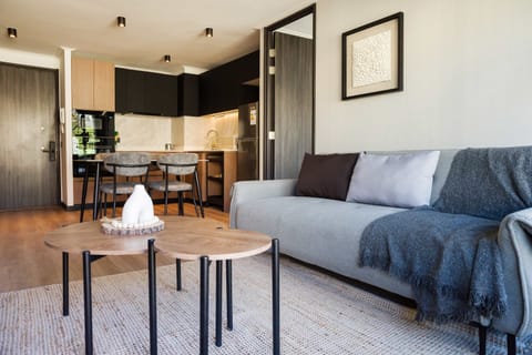 Modern living area with cozy seating and a stylish kitchen, perfect for relaxing or entertaining.