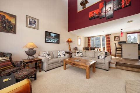 Unwind in your spacious living room with cozy sectional seating, warm lighting, and rustic wood coffee table perfect for family gatherings.