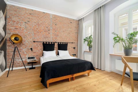 Stylish bedroom area with exposed brick wall and elegant black decor.