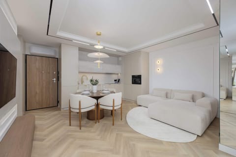 The bright living room with a soft cream sofa and subtle lighting creates an atmosphere of relaxation and elegance, perfect for peaceful evenings after a day in the city.
