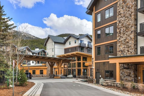 Entrance area with wooden structures and parked vehicles.