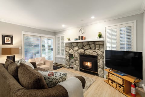 Living room with TV, fireplace, and door to back patio