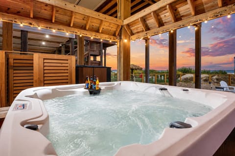 Luxury beachfront hot tub retreat with covered outdoor lounge, sunset views, and relaxing spa experience at Ocean Waves in Crystal Beach, Bolivar Peninsula TX.