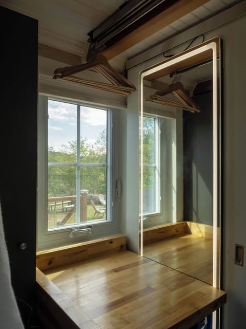 Full length lighted mirror and makeup area with stool, wardrobe, hanging bar