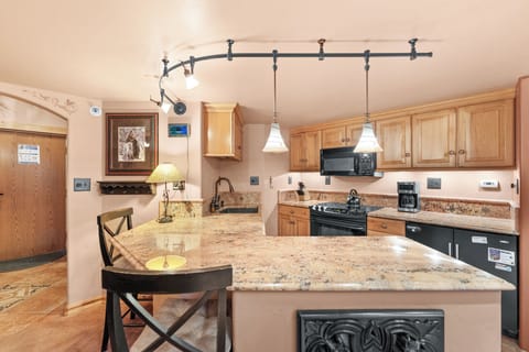 Full kitchen with a breakfast bar, seating 2.