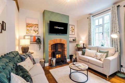 The beautiful living room features 2 sofas, a smart TV and a log burner, perfect for cozying up in the evening to relax.