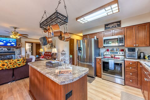 Kitchen | Fully equipped with stainless steel appliances, wood cabinetry, and ample counter space.