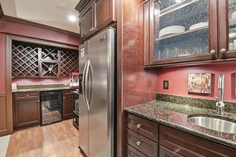 Another view of kitchen area with wine racks/fridge.
