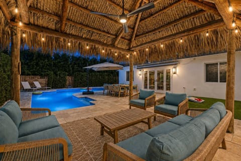 Beautiful covered outdoor living area overlooking the pool, creating an inviting space for evening cocktails, conversation, and outdoor dining.