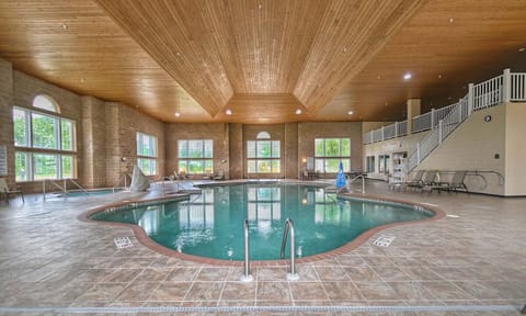 Dive into a sunlit indoor pool under warm timber ceilings.