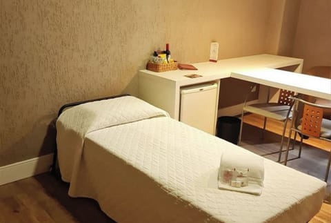 Kick back on a cozy bed beside handy minibar storage.