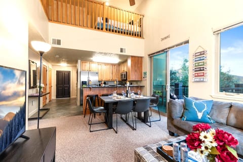 Soaring ceilings and an open loft above give this living space a grand, airy feel.