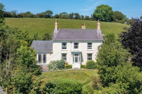 Farmhouse with mature gardens, surrounded by fields