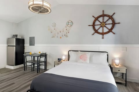 Nautical bedroom with wall decor and cozy white bedding.