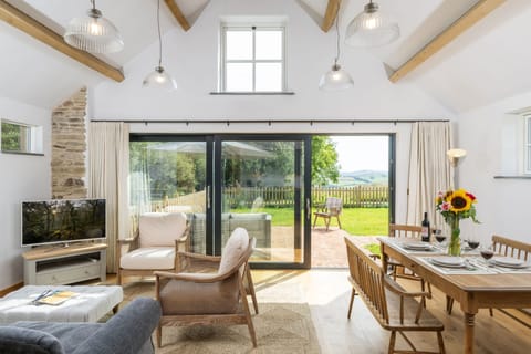 The double height living area is filled with natural light and the stunning view framed by the bi-folding doors