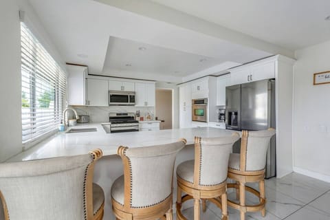 Modern, fully equipped kitchen with stainless steel appliances, spacious countertops, and seating for casual dining.