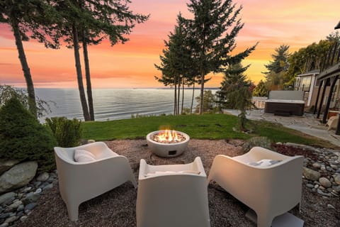 Sunset serenity by the bay — gather around the firepit and soak in panoramic ocean views framed by evergreens.