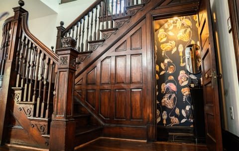 There is a moody half bathroom under the antique staircase by the dining room