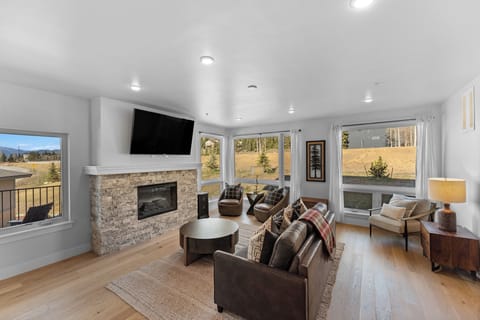 Cozy up by your stone fireplace while mountain views stretch beyond every window in this inviting living space.