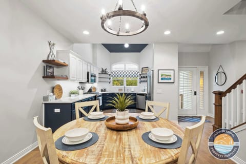 Bright dining area with modern table seating 6-8 guests, perfect for family meals and game nights. Large windows provide natural light and views creating an inviting atmosphere for gatherings