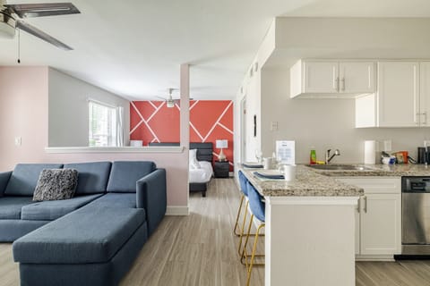 Bright open-concept studio with stylish kitchen and bold accent wall