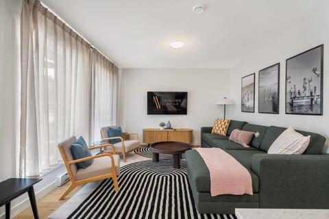 Living room with a smart TV, cozy seating options and a queen-sized pull-out sleeper sofa (all bedding provided.)