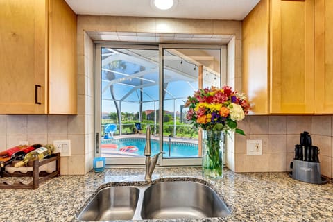 Kitchen | Granite Countertops, Stainless Steel Appliances, and Poolside View with Breakfast Bar
