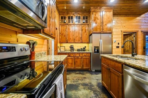 Fully equipped kitchen with stainless appliances and rich wood cabinetry.