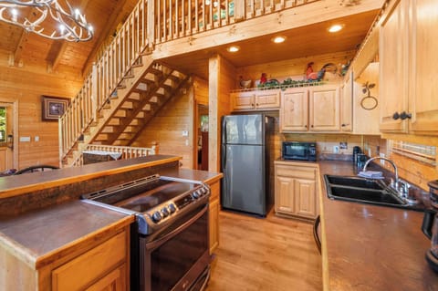 Fully equipped kitchen with stainless steel appliances & bar seating.