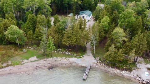 Aerial view showing the cottage, private shoreline, and dock access on beautiful Lake Huron.
