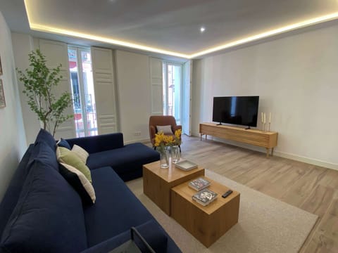Bright living room with cozy seating and TV.
