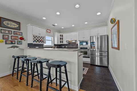 A fully equipped kitchen with a bar seating for 4. 