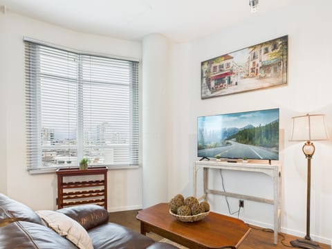 Welcome to your urban haven! Comfortable living room space featuring picture windows for ample natural light and direct sightlines across the downtown suite.
